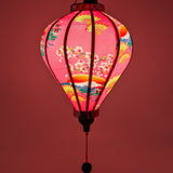 Glowing soft pink silk lantern, handmade in Hoi An, perfect for weddings, home decor, and cozy lighting.