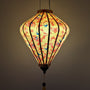 Glowing diamond shaped lantern with floral and bird pattern on a yellow background