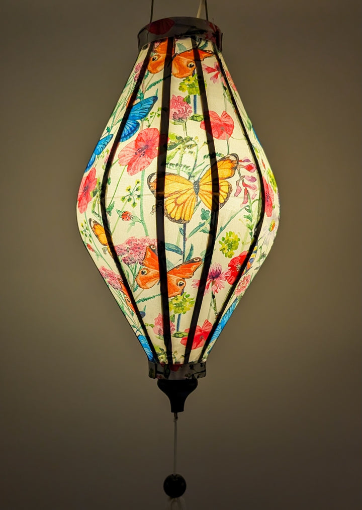 Lantern with floral and butterfly design on a plain background creating a warm glow