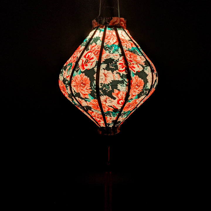 Glowing Lozenge silk Vietnamese Hoi An lantern with pink carnations on black silk.