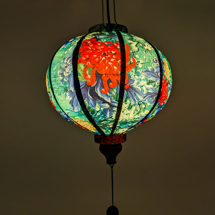 Close up of the round Vietnamese lantern with blue tassels and chrysanthemum flowers.