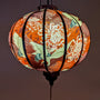 Glowing round Vietnamese lantern featuring cranes and chrysanthemum flowers.