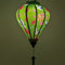 Glowing Vietnamese silk lantern for sale with green background adorned with elegant white cranes in flight, their wings gracefully spread with black and blue accents. 