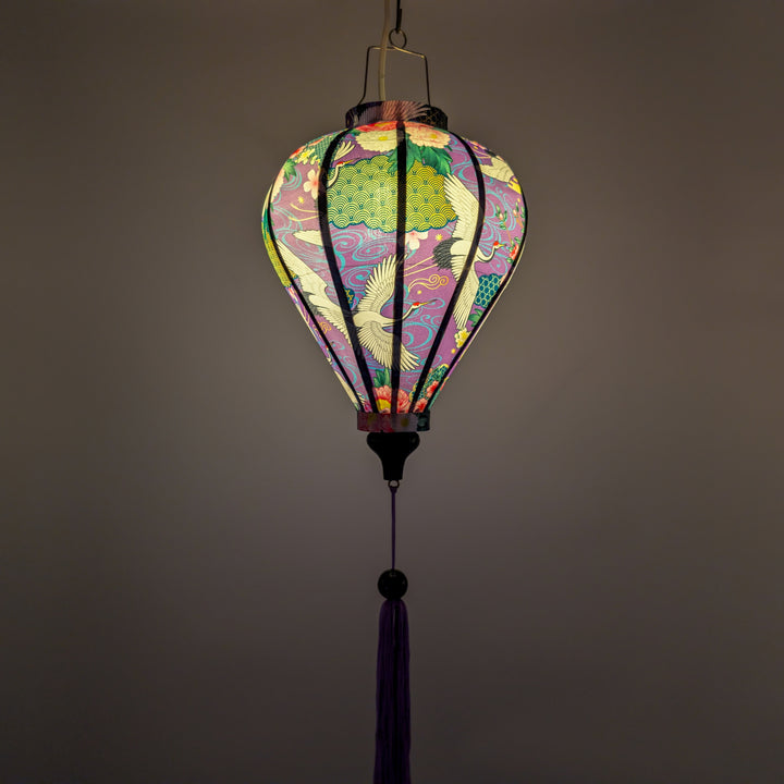 Glowing purple silk lantern with geometric shapes, flowers and cranes in flight.