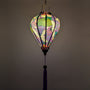 Glowing purple silk lantern with geometric shapes, flowers and cranes in flight.