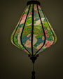 Lantern with a light inside with floral and cranes creating a green glow.