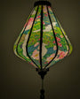 Lantern with a light inside with floral and cranes creating a green glow.