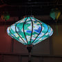 Glowing UFO shaped Vietnamese lantern being lit from inside using an external light.