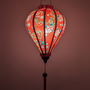 Glowing Vietnamese silk lantern with floral and dragon pattern on a red background