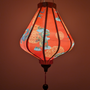 Glowing Teardrop shaped Vietnamese silk lantern with dragon design on a red background