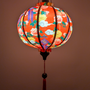 Decorative round glowing lantern for Lunar New Year celebrations with floral patterns on a red background