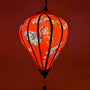 Glowing Balloon shaped Vietnamese silk lantern created a warm red hue.