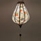 Up close glowing Garlic shaped Vietnamese Lantern with a beautiful illustration of flowers in blue, green and orange colours against cream background.
