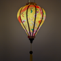 Glowing Vietnamese silk lantern with floral design on a yellow background