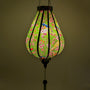Glowing Garlic shape lantern with green hue featuring blue and yellow fly catcher birds sitting in a cherry blossom tree.