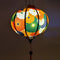 Glowing round Vietnamese lantern with flowers in colours orange, white, green, dark blue and gold outline.