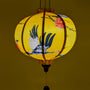 A Vietnamese lantern in round shape creating a golden yellow glow.