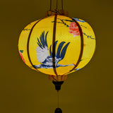 A Vietnamese lantern in round shape creating a golden yellow glow.