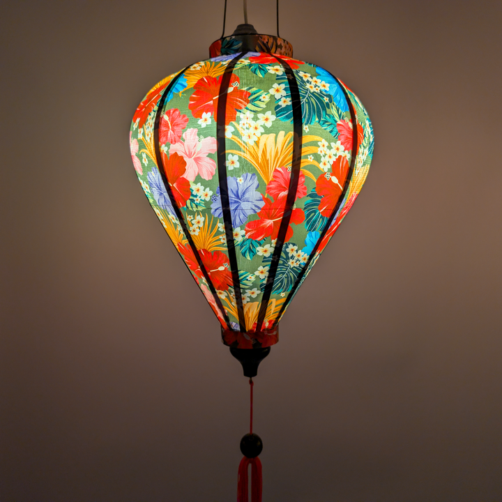 Glowing Hibiscus flowers lantern with colourful floral pattern on an olive green background.