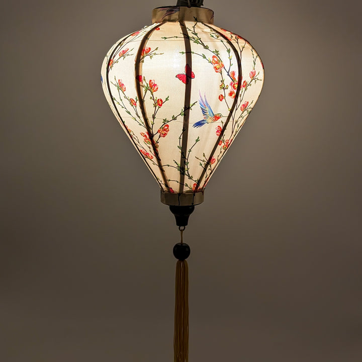 Glowing balloon shape Vietnamese silk lantern with hummingbirds and flowers on cream silk.