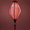Glowing Tube shaped lantern with a print of hummingbirds mid-flight hunting nectar from orange flowers against striking pink background.