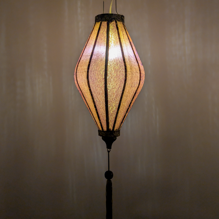 Glowing Vietnamese lantern with a textured gold and grey jacquard silk fabric.