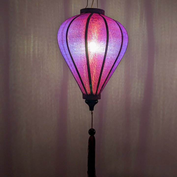 Purple & Red Jacquard silk lantern with a light bulb inside creating a purple glow.