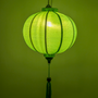 Round glowing sea green jacquard silk lantern creating a green glow.