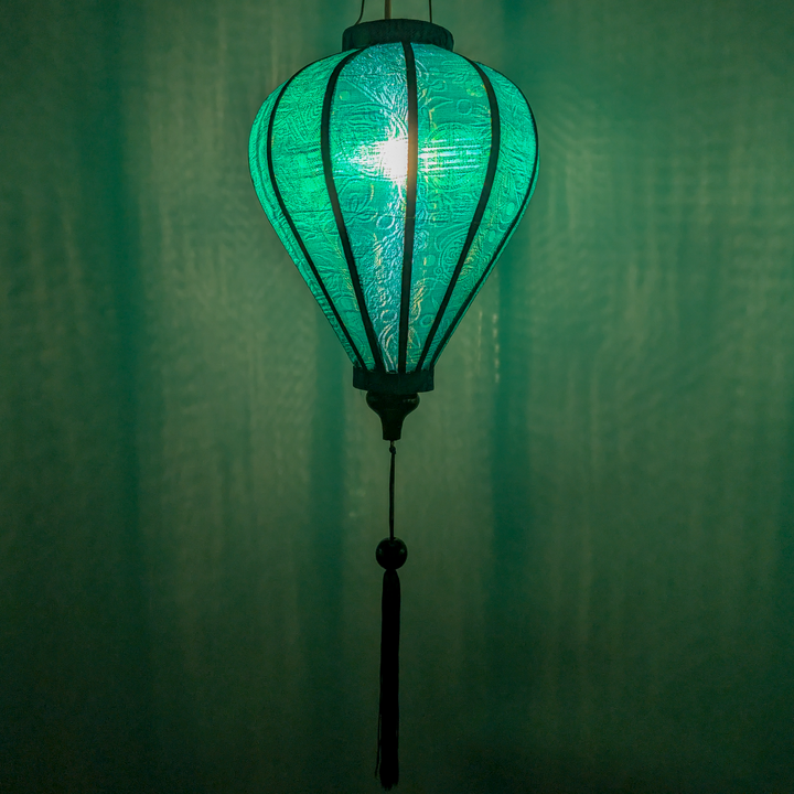 Balloon shaped lantern created in Teal green jacquard silk with hints of blue creating a green glow.