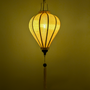 Traditional yellow colour Jacquard silk lantern hanging lantern with a warm glow creating a yellow background