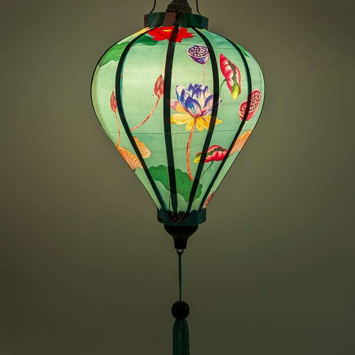 Glowing balloon shape lantern with delicate petals, lush green leaves and detailed lotus seed pods in shades of pink, blue, and yellow create a gorgeous contrast.