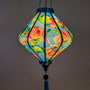 Close up of a glowing Lozenge shaped lantern with cranes and lotus flowers creating a beautiful soft blue hue.