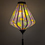 Glowing lantern with floral and mushroom pattern on a rich purple.