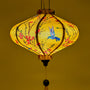 UFO shaped lantern being lit from inside with little hummingbirds mid-flight hunting nectar from orange and pink flowers creating a gorgeous glowing yellow hue.