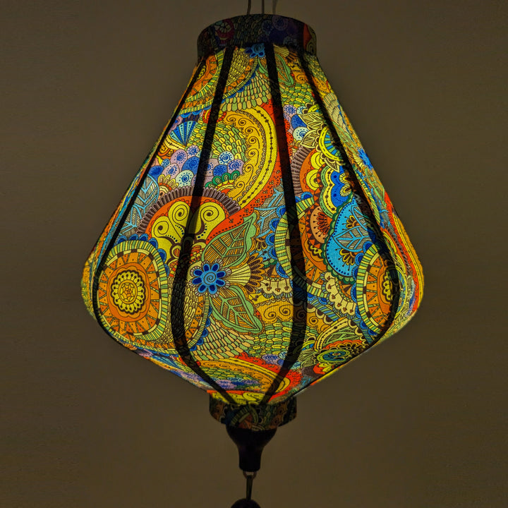 A close up of a Teardrop shaped lantern with paisley print, using an external light source to create a soft glow.