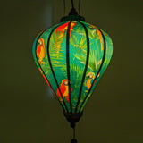 Balloon shaped Vietnamese lantern glowing with a gorgeous green hue.