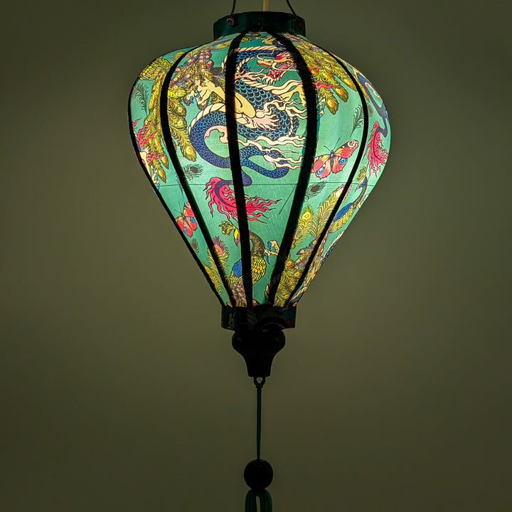 A glowing Vietnamese silk lantern featuring a vibrant blue background with majestic dragons and elegant peacocks. 