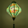 Glowing  lantern with floral and bird design on a teal colour background