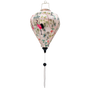 A balloon shaped Vietnamese lantern , handmade in Hoi An with vibrant fabric print featuring elegant pink and black cranes among lush green foliage and delicate blooming flowers. The scene is accented with traditional Asian-style pagodas, creating a serene yet bold aesthetic with rich colors.