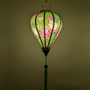 Glowing balloon shaped Vietnamese silk lantern with green backdrop