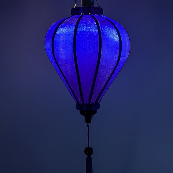 Balloon shape dark blue polyester silk lantern glowing with a blue hue. Handmade in Vietnam.