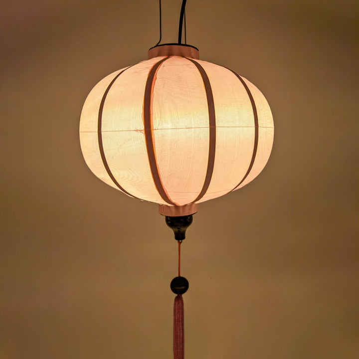 Glowing light pink plain polyester silk lantern made with fabric and bamboo from Hoi An, Vietnam.
