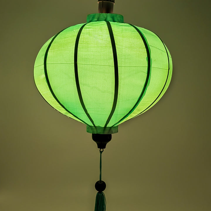 Round Vietnamese lantern with glowing mint green hue.