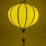 Round glowing yellow Vietnamese lantern for sale.