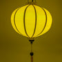 Round glowing yellow Vietnamese lantern for sale.