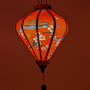 Close up of a Diamond shape lantern with a red glow.