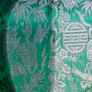 A close up up sea green and silver jacquard silk fabric.