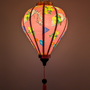 Glowing pink lantern with fan designs and floral patterns.