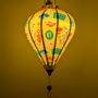 Glowing yellow lantern with colourful Lunar New Year patterns on a yellow background