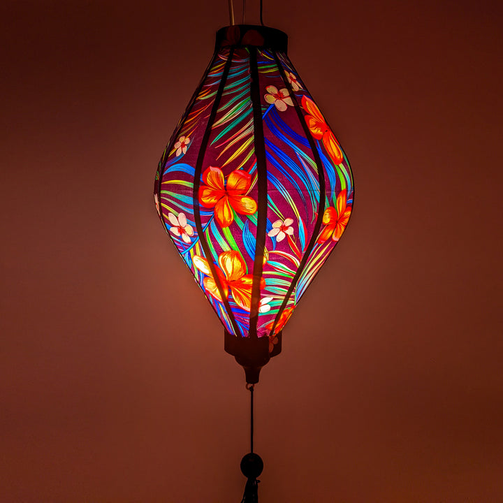 Glowing Tube shaped lantern with tropical flowers and palm leaves.